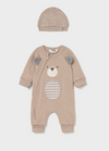 Beige bear onesie with a matching hat, featuring a bear face design, ears, and striped belly patch.
