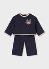 Navy blue baby sweatsuit with a cat motif on the top and beige accents at the cuffs and hem.