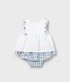 White top and blue checkered shorts set with red floral details on a light gray background