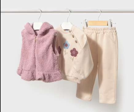 Toddler beige sweatsuit with floral embroidery and pink fur vest on hangers.
