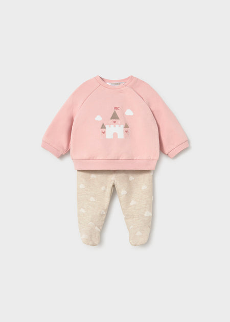 A pink infant pullover with a castle motif, paired with beige pants featuring a cloud pattern.