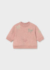 Pink sweatshirt with bow accents and denim pants set for infants.