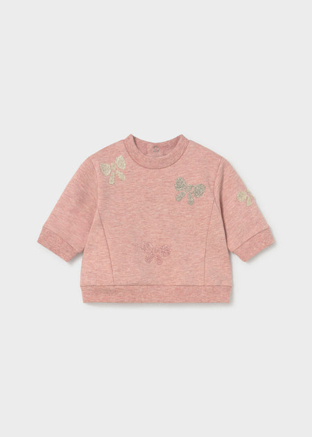 Pink sweatshirt with bow accents and denim pants set for infants.