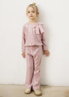 Girl wearing a pink sparkle two-piece set with a bow detail.