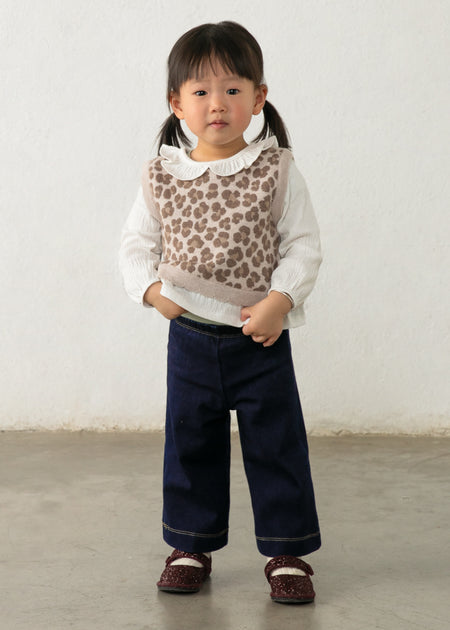 Toddler wearing a leopard faux vest over a white shirt with wide-leg pants.