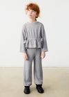 Toddler wearing a grey shimmer 2-piece set with a relaxed fit, featuring a top with decorative bows and matching pants.