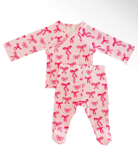 Pink two-piece baby set with bow pattern, featuring a long sleeve top and matching pants.
