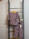 A lavender two-piece set with white cloud print, featuring a long sleeve top with ruffles and jogger pants.