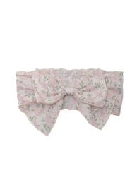 A soft pink headband with a large bow and delicate floral print.
