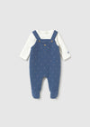 Navy footie with polka dots, designed to look like overalls, featuring long sleeves and foot coverage.