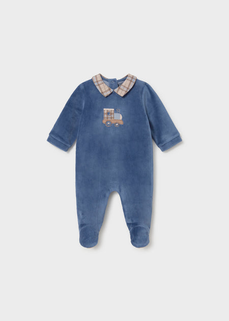 A navy velour footie with a plaid collar and an embroidered train design on the front.
