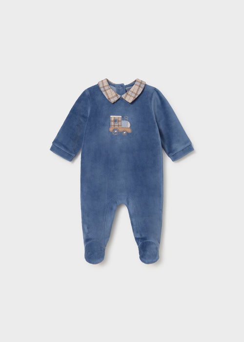A navy velour footie with a plaid collar and an embroidered train design on the front.