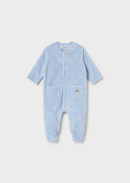 A blue velour footie with a cloud pattern, featuring a snap front and two front pockets.