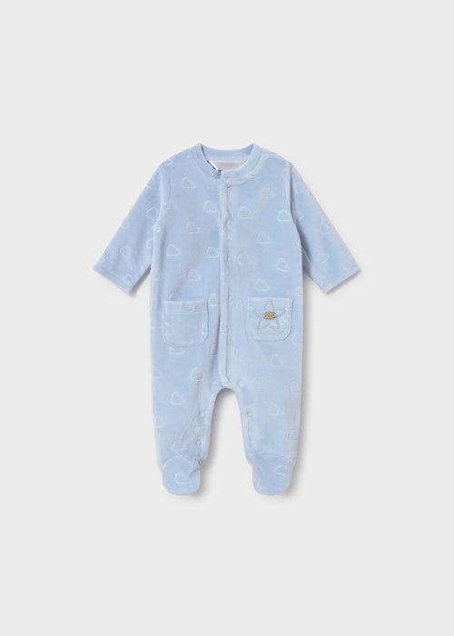 A blue velour footie with a cloud pattern, featuring a snap front and two front pockets.