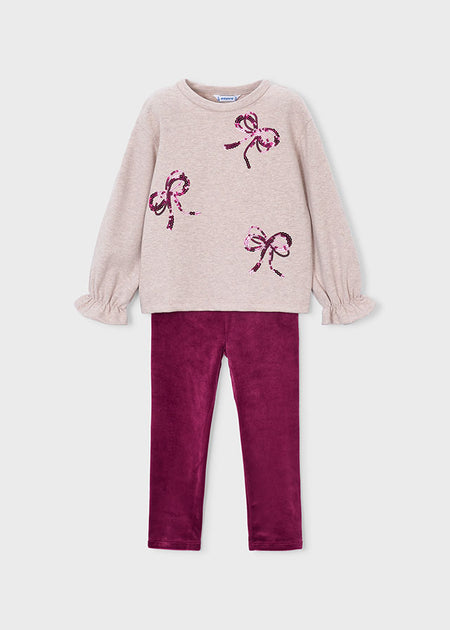 Toddler outfit with beige bow-embellished top and raspberry velour leggings.