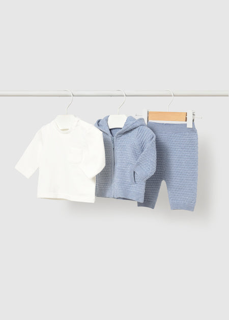 Blue knit hoodie, pants, and white long-sleeve t-shirt set for infants on hangers.